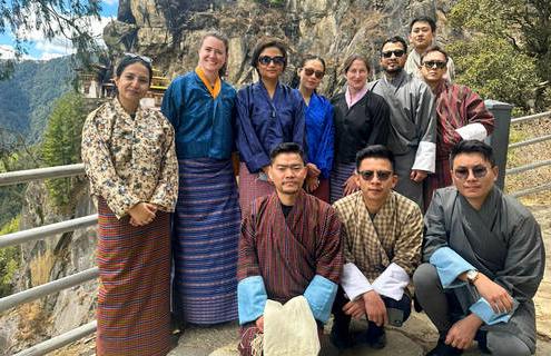 医生们穿着不丹传统服装在山腰摆姿势